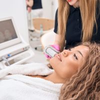 Patient in the clinic of aesthetic medicine undergoes a painless smas-lifting procedure on modern high-tech equipment by a professional cosmetologist