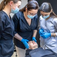 Team of female dentists treating patient's teeth. Visit to the dentist. Dentistry. High quality photo. Dentists in rubber gloves and medical masks on their faces. Dental office. SSUCv3H4sIAAAAAAAAA41PQY6DMAz8i88gEVJU4CvVHkJiqFUgVWK2WqH8fR1KtdfNacYTz4x3IAc9qEvTVdVQlWOHtlQKx7J19bVUY9voa9u1WGsowBlG6JXWbdNdaqXrVutKXgGDiWSh34HmeYscDJNfoRcl4OowHBAdsQ9kZmGpgMiGt4hR1oRZ8Z5EPfjH77bnuRSU8LgNGaTin7OvAsyEq/3J/ikXmdEccTeRHi/GsJzZnu+5YobPQJbW6ewkp/jljVfPefdIYG8f5M7l9xl3kmnIWbA9Z28culPehoWYPzTgN+Hr73dK6ReyERMthAEAAA==
